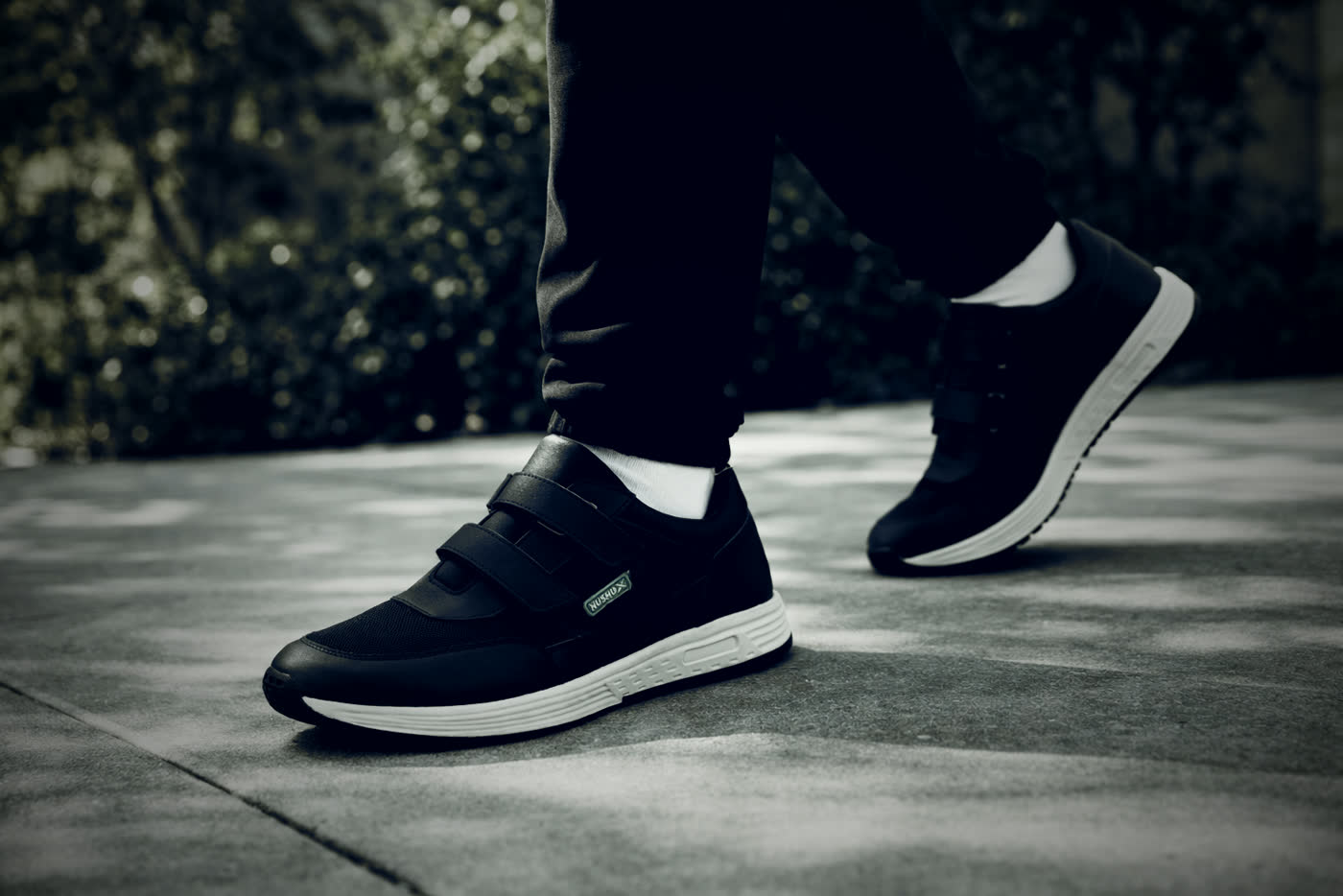 NUSHU shoes mid-stride on pavement